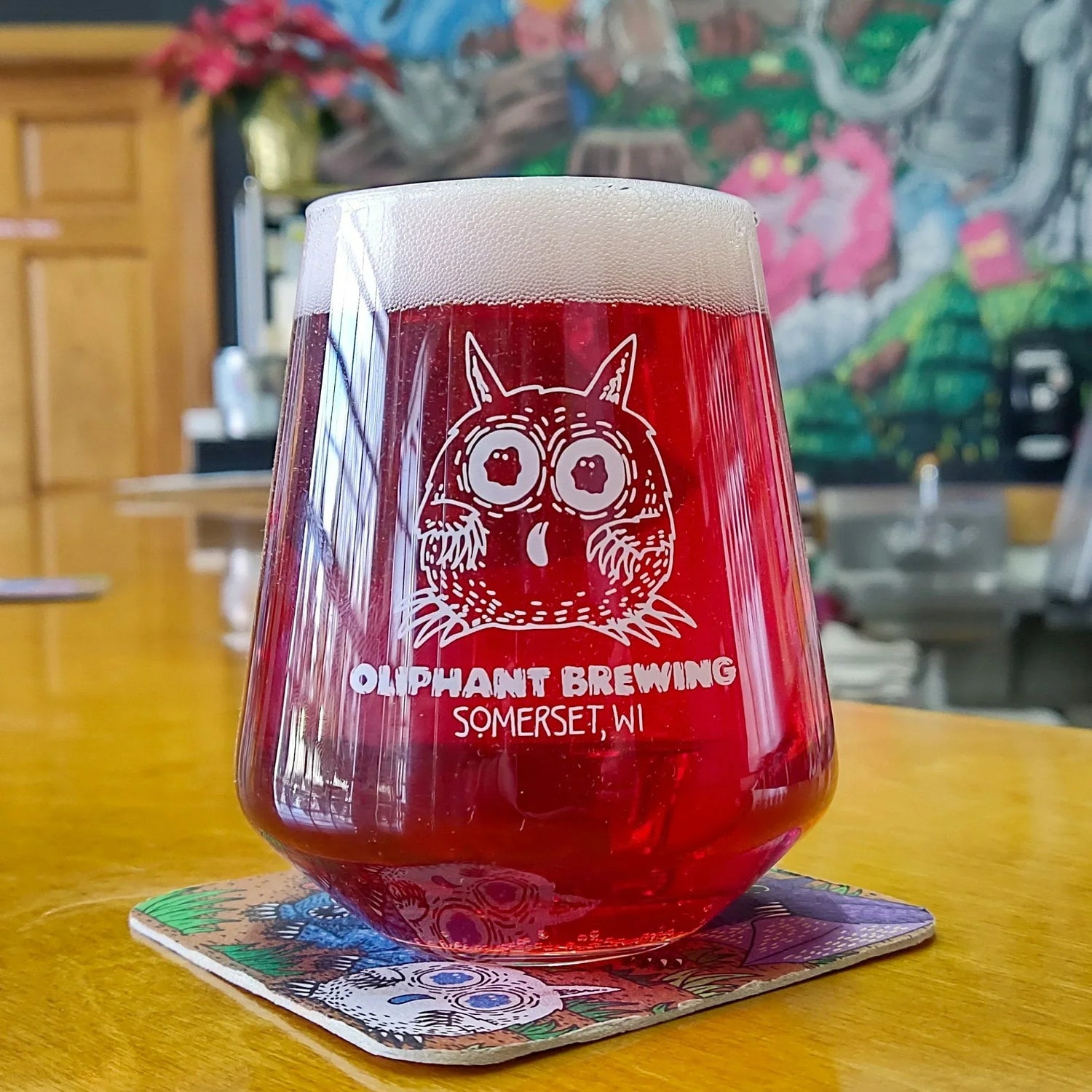 Oliphant Brewing tulip glass with red craft beer on bar, Somerset WI brewery taproom