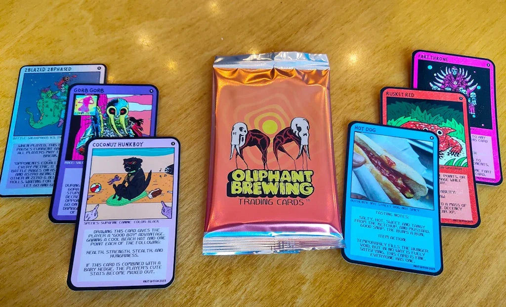 Oliphant Brewing trading cards pack with colorful fantasy cards on a wooden table
