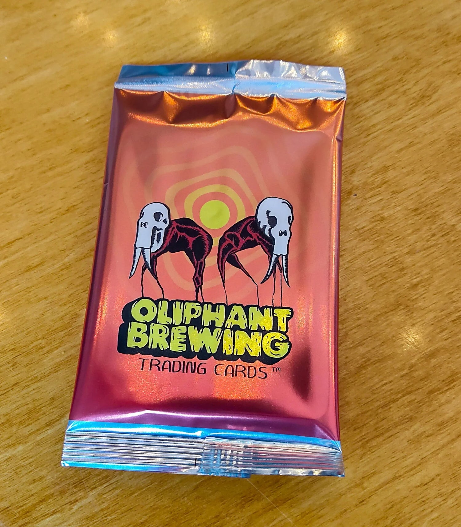 Oliphant Brewing trading cards foil pack on wooden table with stylized mammoth skulls