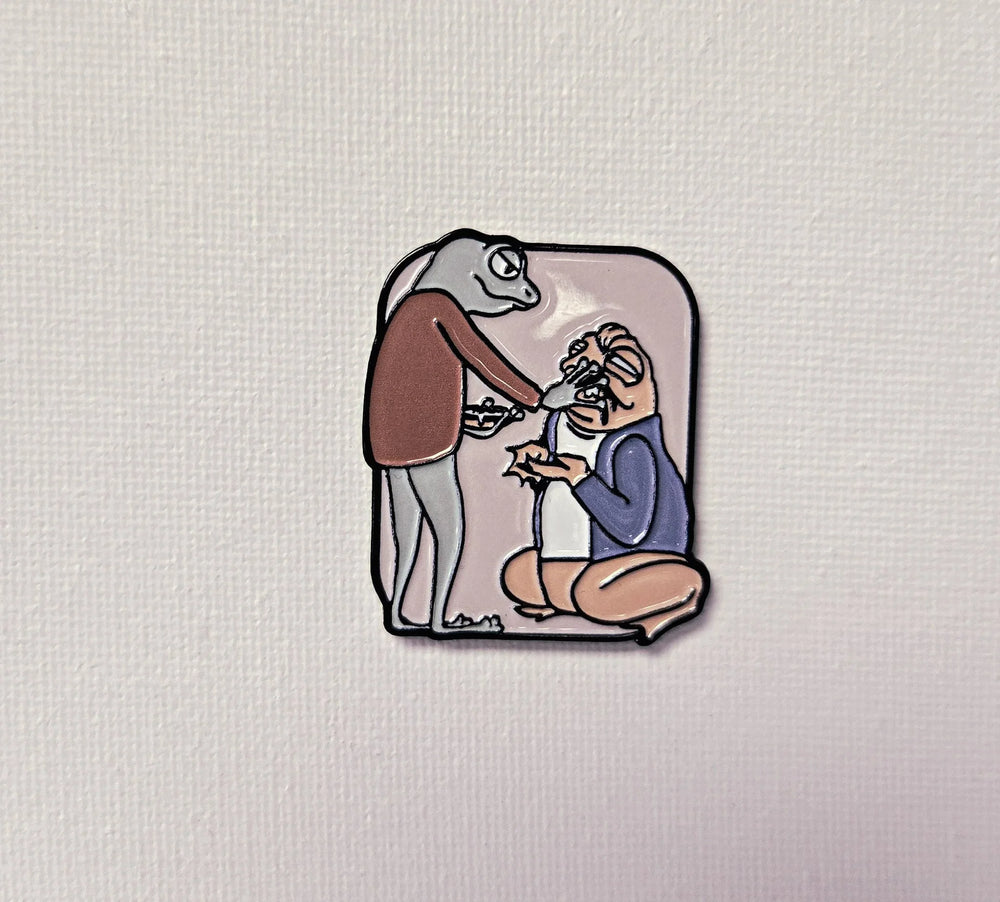 Enamel pin of a cartoon lizard feeding salad to a squatting person on white canvas